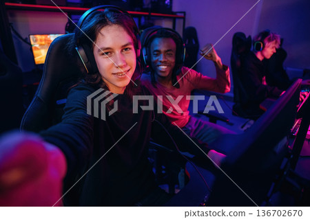 Selfie time. Gamers are playing video game by computers Selfie time. Gamers are playing video game by computers 136702670