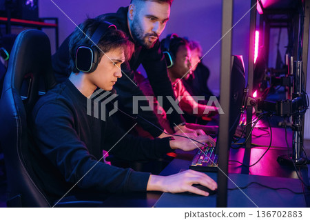 Using keyboard and mouse. Gamers are playing video game by computers 136702883