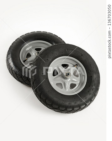 Two wheels from a garden cart on a white background. Black rubber, grey disc. Two wheels from a garden cart on a white background. Black rubber, grey disc. 136703050