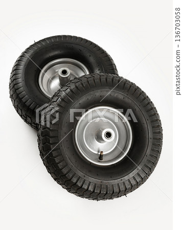 Two wheels from a garden cart on a white background. Black rubber, grey disc. Two wheels from a garden cart on a white background. Black rubber, grey disc. 136703058