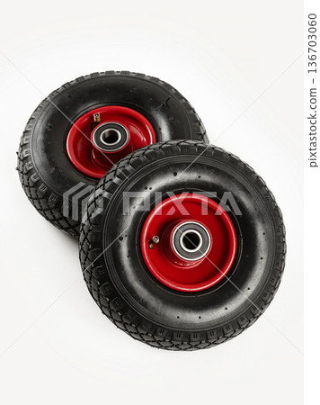 Two wheels from a garden cart on a white background. Black rubber, red disc. Two wheels from a garden cart on a white background. Black rubber, red disc. 136703060