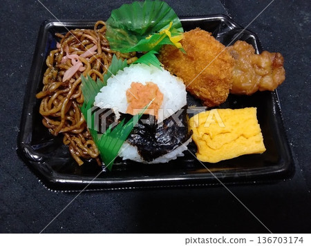 A great value mini rice ball and fried soba bento from the supermarket 136703174