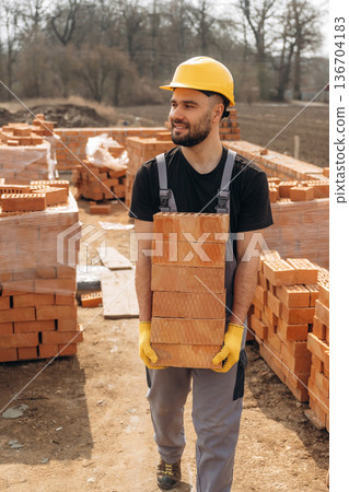 Bunch of bricks. Construction worker is at job outdoors Bunch of bricks. Construction worker is at job outdoors 136704183