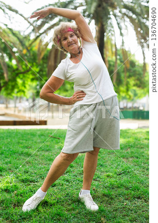 Mature woman training in park Mature woman training in park 136704690