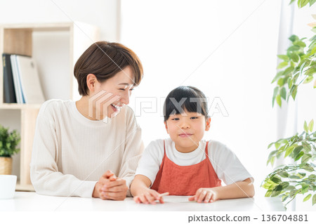 一位母親站在正在學習的小學生孩子旁邊。 136704881