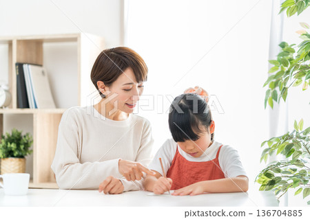 一位母親站在正在學習的小學生孩子旁邊。 136704885