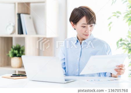 一位女士正在客廳遠距辦公。 136705768