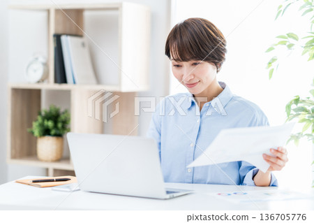 一位女士正在客廳遠距辦公。 136705776
