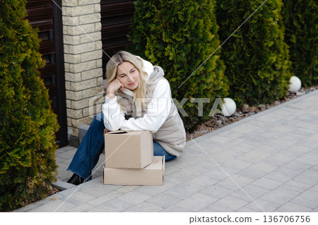 Happy customer receiving online order smiling and relaxing next to cardboard boxes Happy customer receiving online order smiling and relaxing next to cardboard boxes 136706756