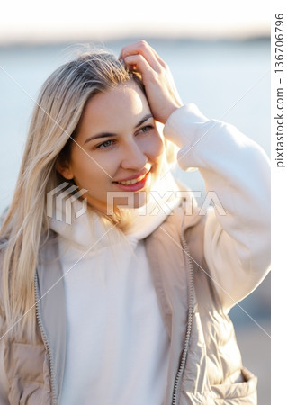 Young blonde woman looking away, enjoying sunlight on a beach 136706796