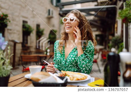 Young Woman eating Italian pasta at restaurant on the street in Rome. Gastronomy and travel 136707057