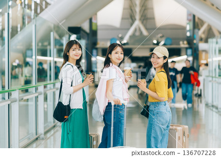 Three women at the airport setting off on a trip (Photography cooperation: Kansai International Airport (KIX)) 136707228