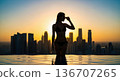 Woman in bikini enjoying sunset at rooftop infinity pool 136707265