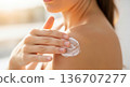 Woman applying sunscreen lotion on shoulder for skin protection 136707277