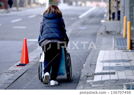 Yokohama cityscape in Japan: Steps and unevenness... Aging society: Elderly woman in wheelchair (no markings) has a hard time pushing... = Yokohama city 136707498