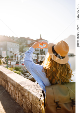 Woman tourist holding hands in shape of heart looking at panoramic landscape of city. Lifestyle. Woman tourist holding hands in shape of heart looking at panoramic landscape of city. Lifestyle. 136707609