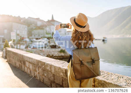 Woman taking picture of amazing landscape on smartphone during vacation. Travel, tourism, lifestyle. 136707626