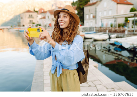 Female tourist taking images of city during leisure time for creating publication in blog. Lifestyle 136707635