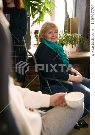 Senior manager smiling during informal staff discussion. Senior manager smiling during informal staff discussion. 136707704