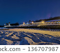 View of a coastal cafe from the frozen shore in winter at sunset 136707987