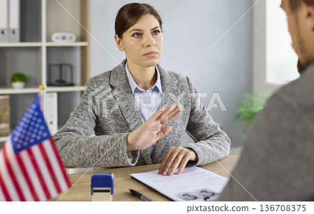 Immigration denial and rejection by officer showing refusal gesture to applicant 136708375