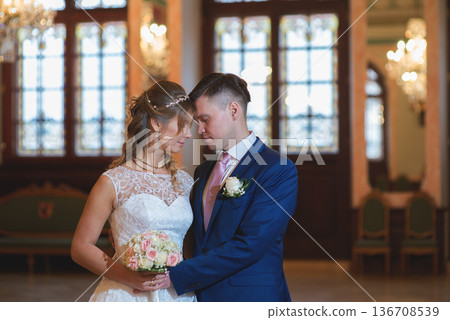 Elegant Wedding Couple Holding Bouquet In Ceremony Hall 136708539