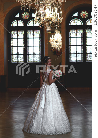 Bride Looking Back In Ornate Wedding Hall 136708547