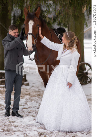 Wedding Couple Gently Petting Horse Together Wedding Couple Gently Petting Horse Together 136708572