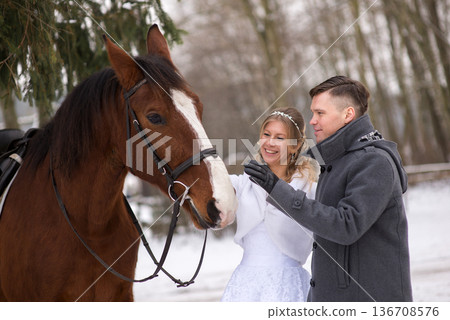 Bride Gently Touching Horse During Winter Wedding Bride Gently Touching Horse During Winter Wedding 136708576