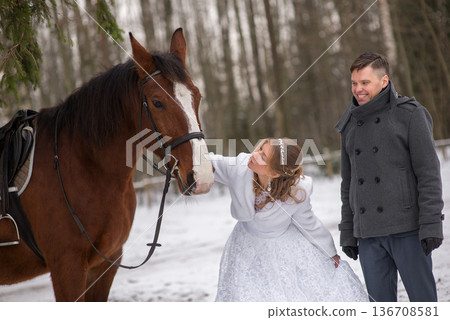 Bride Leaning Toward Horse In Snowy Landscape 136708581