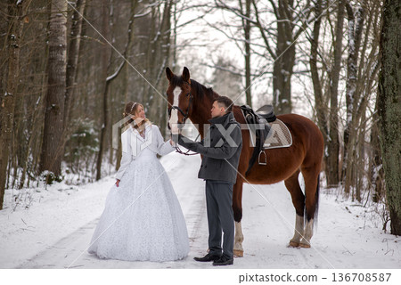 Elegant Winter Bride Standing Beside Horse Outdoors Elegant Winter Bride Standing Beside Horse Outdoors 136708587