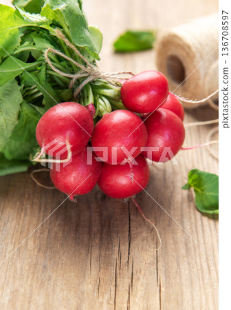 Fresh organic radishes with green leaves on wood 136708597