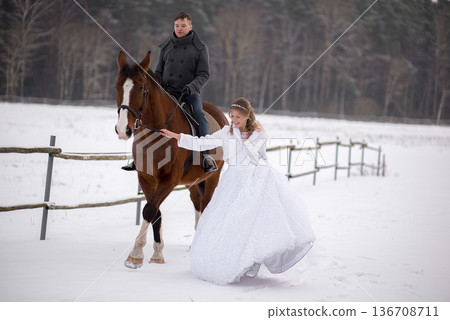 Bride Walking Beside Horse During Winter Wedding Bride Walking Beside Horse During Winter Wedding 136708711