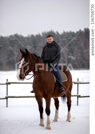 Smiling Groom Riding Horse In Winter Field Smiling Groom Riding Horse In Winter Field 136708730