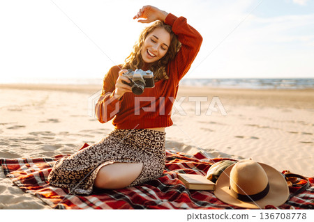 Happy woman with retro camera on the beach. Travel, weekend, relax and lifestyle concept. Happy woman with retro camera on the beach. Travel, weekend, relax and lifestyle concept. 136708778