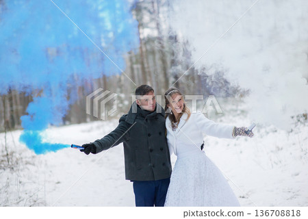 Joyful Bride And Groom Posing With Smoke Flares In Snow Joyful Bride And Groom Posing With Smoke Flares In Snow 136708818