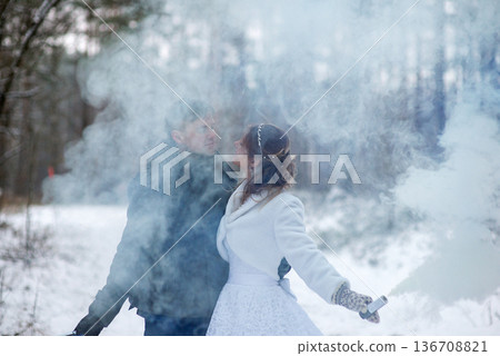 Bride And Groom Surrounded By Soft Smoke In Winter Forest 136708821
