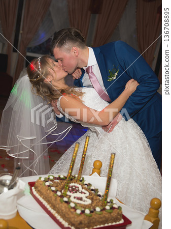 Emotional Wedding Kiss Beside Decorated Celebration Cake Emotional Wedding Kiss Beside Decorated Celebration Cake 136708895