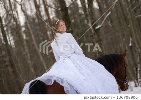 Bride Riding Horse Along Snowy Forest Road 136708906