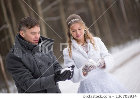 Bride and Groom Examining Snow In Gloves Bride and Groom Examining Snow In Gloves 136708934