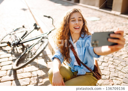 Young woman with bike outdoors in park in summer day using mobile phone. Travel, relax and lifestyle Young woman with bike outdoors in park in summer day using mobile phone. Travel, relax and lifestyle 136709136