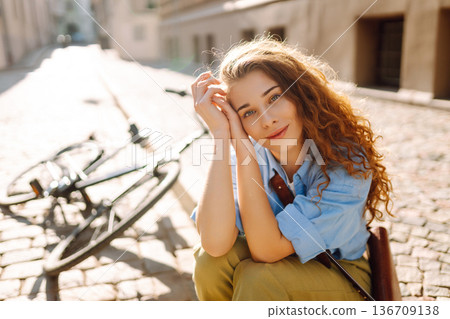 Beautiful smiling woman sitting next to bike on the street city. Adventure Concept Beautiful smiling woman sitting next to bike on the street city. Adventure Concept 136709138