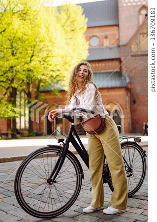 Beautiful woman riding bicycle at the city street outdoor. Active lifestyle. Eco transport. Beautiful woman riding bicycle at the city street outdoor. Active lifestyle. Eco transport. 136709181