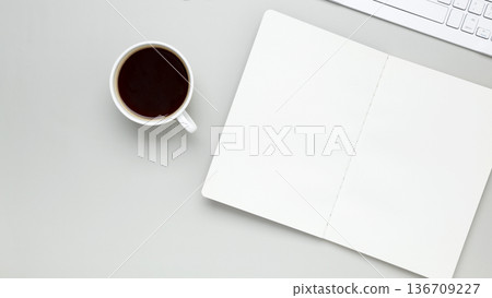 Cozy workspace with coffee cup, keyboard, glasses creating focused morning atmosphere 136709227