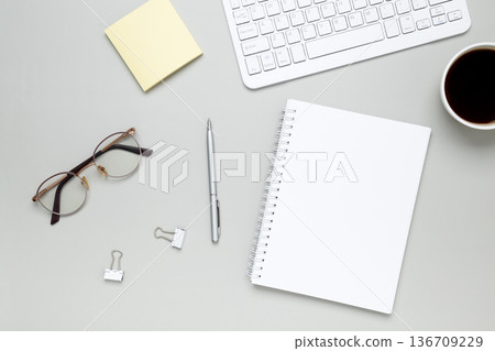 Minimal workspace with coffee cup, glasses and notebook creating calm focused atmosphere Minimal workspace with coffee cup, glasses and notebook creating calm focused atmosphere 136709229