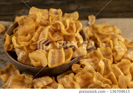 mashed potato chips fried in a large amount of sunflower oil, sprinkled with red hot pepper spices, delicious high-calorie chips with spices are scattered on the table mashed potato chips fried in a large amount of sunflower oil, sprinkled with red hot pepper spices, delicious high-calorie chips with spices are scattered on the table 136709615