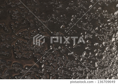 wet embossed black slate for serving, covered with lots of water drops kitchen board made of black embossed slate, closeup wet embossed black slate for serving, covered with lots of water drops kitchen board made of black embossed slate, closeup 136709649