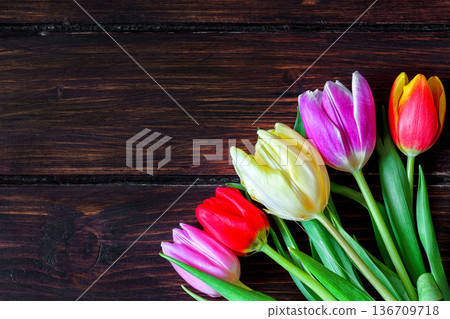 Bouquet of tulips on a dark wooden table. Bouquet of tulips on a dark wooden table. 136709718