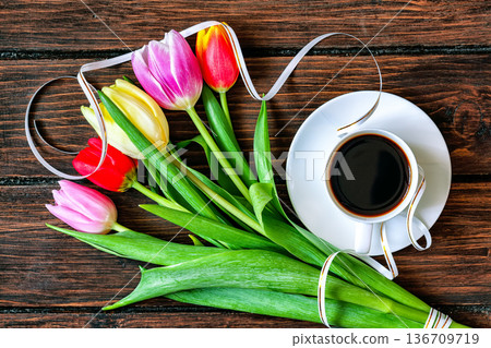 A cup of coffee and bouquet of tulips on a dark wooden table A cup of coffee and bouquet of tulips on a dark wooden table 136709719
