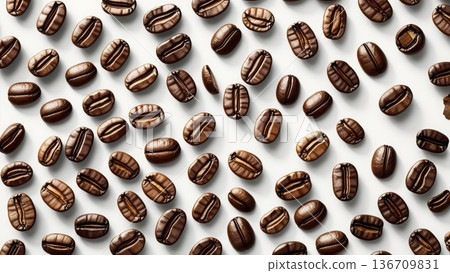 The scattered roasted coffee beans create an appealing and textured background on the light surface, perfect for showcasing caffeine-related products or concepts. 136709831
